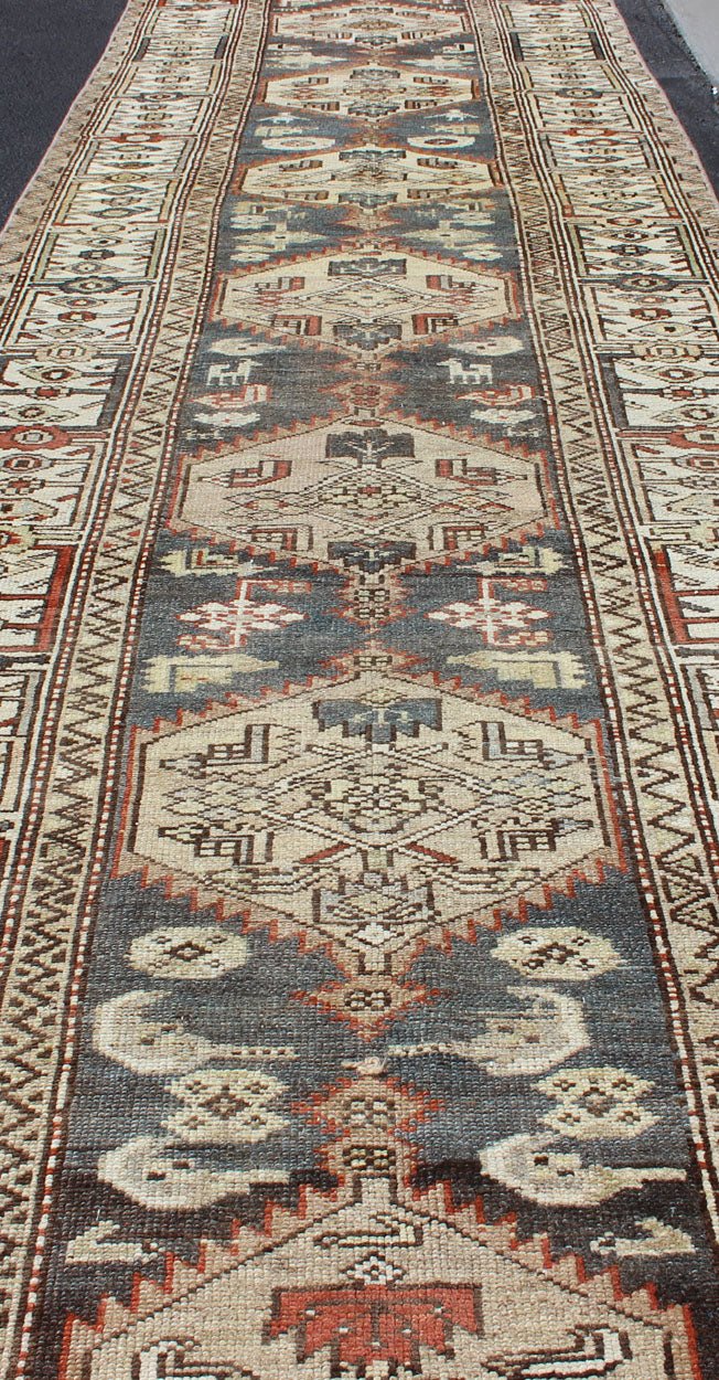Long Persian Kurdish Runner with Medallion Design in Charcoal, Ivory and Red Antique Persian Kurdish long runner with tribal medallions, rug SUS - 1908 - 115, country of origin / type: Iran or Kurdish, circa 1900. Long Persian Kurdish runner in char... - Keivan Woven ArtsSUS - 1908 - 115 - 11529Rug
