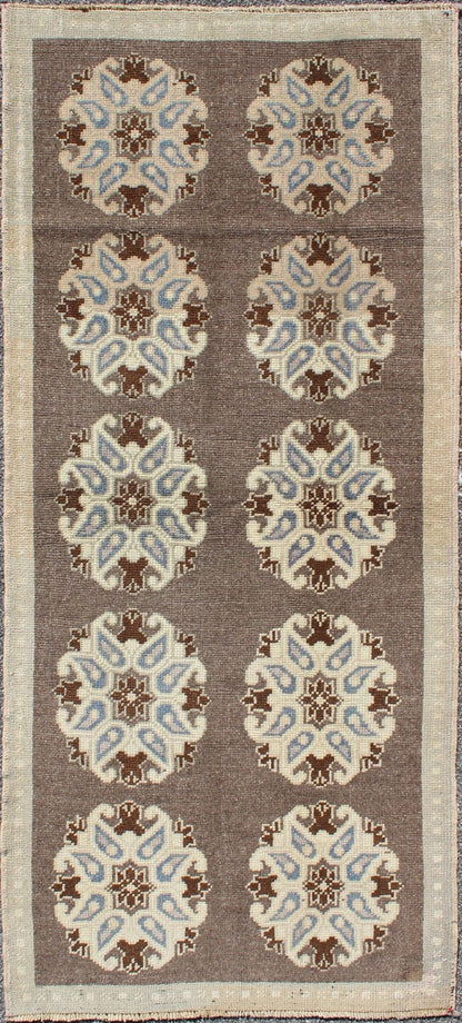 Tribal Turkish Oushak Carpet with Floral Medallions in Taupe, Ivory and Blue Measures: 2'9'' x 6'4''. This Turkish Oushak gallery rug features ten floral medallions that take center stage on a brown field. The border reveals tribal inspiratio... - Keivan Woven ArtsTU - ALK - 3562 - 6787Rug