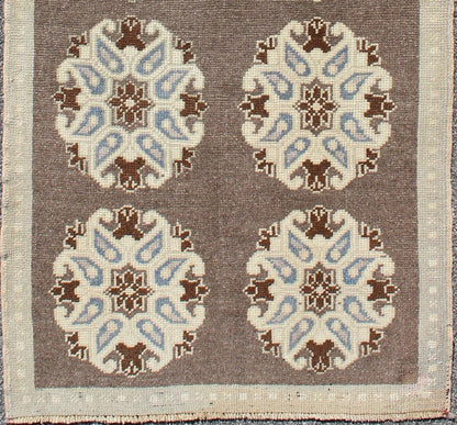 Tribal Turkish Oushak Carpet with Floral Medallions in Taupe, Ivory and Blue Measures: 2'9'' x 6'4''. This Turkish Oushak gallery rug features ten floral medallions that take center stage on a brown field. The border reveals tribal inspiratio... - Keivan Woven ArtsTU - ALK - 3562 - 6787Rug