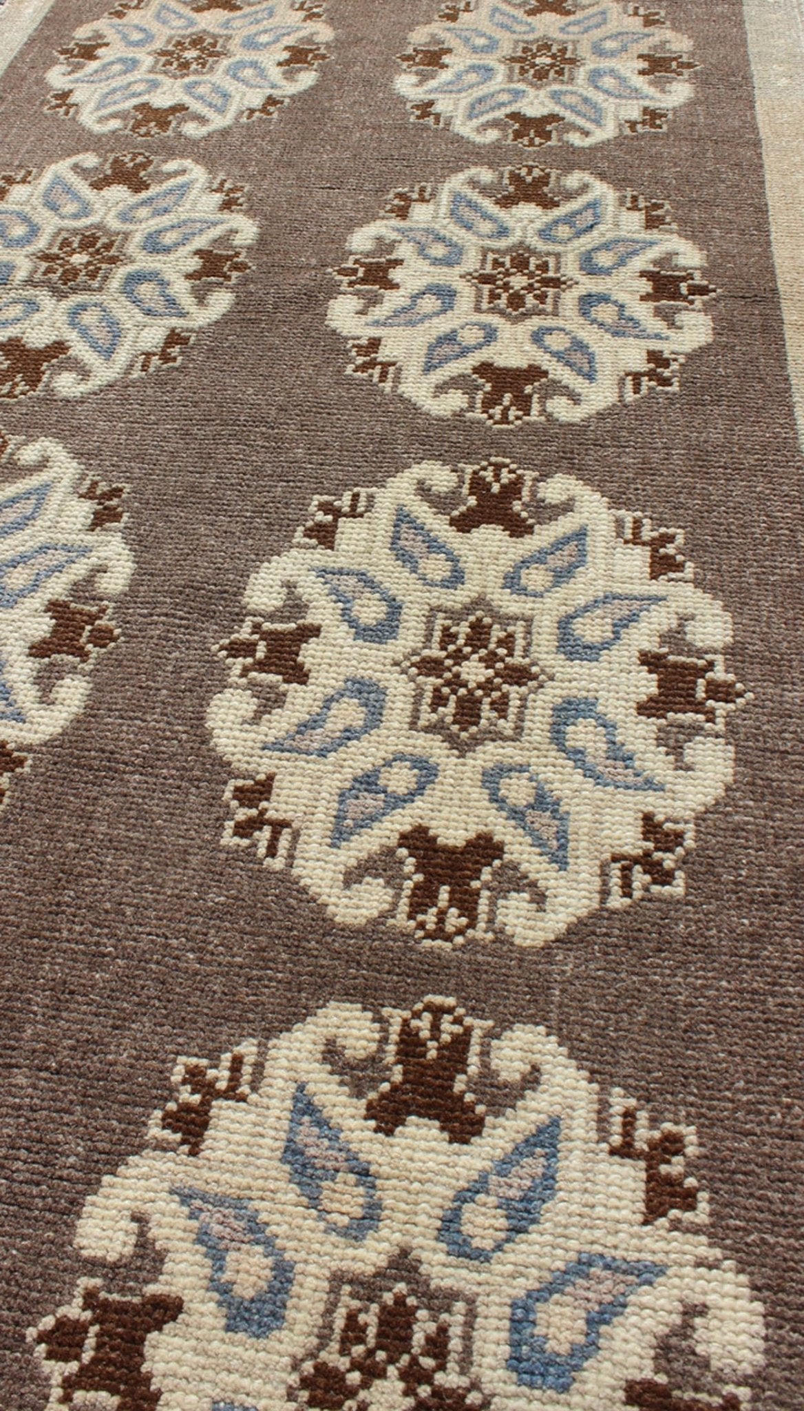Tribal Turkish Oushak Carpet with Floral Medallions in Taupe, Ivory and Blue Measures: 2'9'' x 6'4''. This Turkish Oushak gallery rug features ten floral medallions that take center stage on a brown field. The border reveals tribal inspiratio... - Keivan Woven ArtsTU - ALK - 3562 - 6787Rug