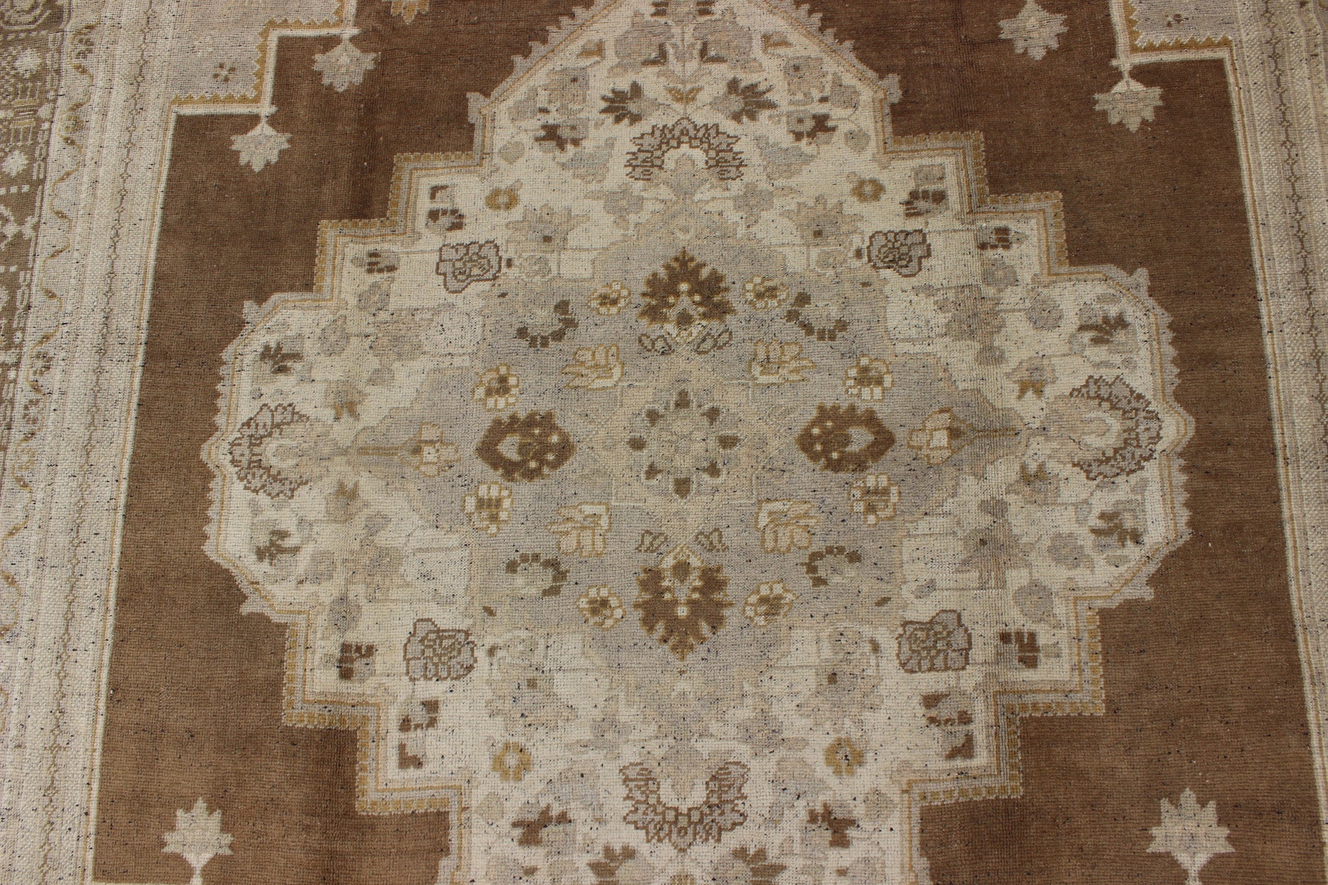 Vintage Turkish Oushak Rug in Brown Background and Neutral Colors Measures: 7'4 x 11'4 This lovely Turkish Oushak from the 1940's features a central medallion, which rests on a dark brown background, is surrounded by a light brown bor... - Keivan Woven ArtsTU - DUR - 506 - 3502Rug