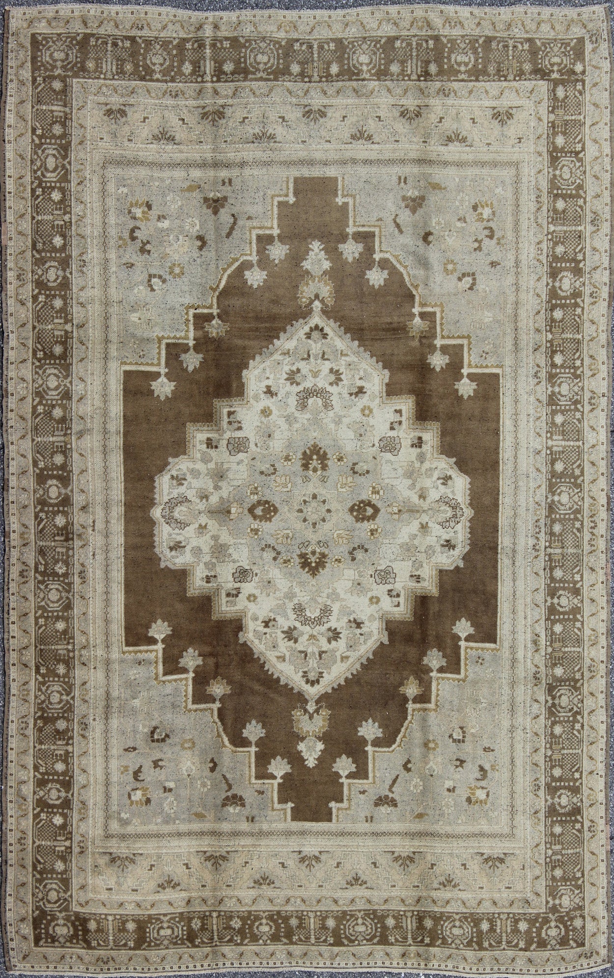 Vintage Turkish Oushak Rug in Brown Background and Neutral Colors Measures: 7'4 x 11'4 This lovely Turkish Oushak from the 1940's features a central medallion, which rests on a dark brown background, is surrounded by a light brown bor... - Keivan Woven ArtsTU - DUR - 506 - 3502Rug