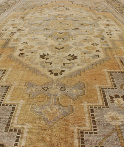 Vintage Turkish Medallion Oushak Rug in Gold, Taupe, Cream and Cocoa Measures: 6'8 x 12 This vintage Turkish Oushak features a bold design softened by unique, light tones. The border is chocolate brown and contains vines and flowers. Co... - Keivan Woven ArtsTU - DUR - 507 - 3508Rug