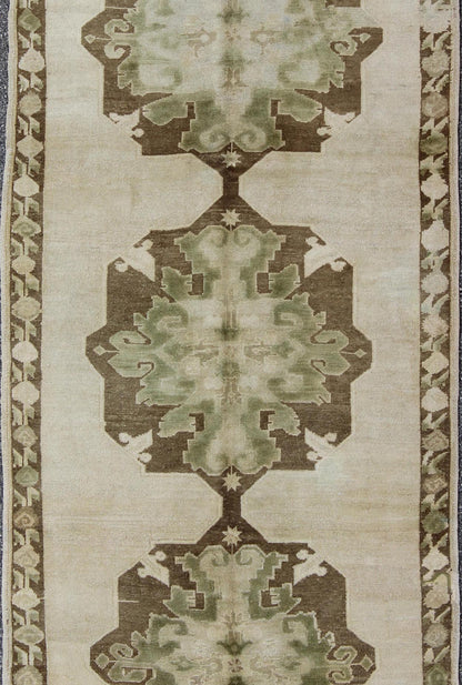 Green Turkish Oushak Runner This lovely Oushak runner displays three elegant medallions of multi - green colors on a solid cream field. The variety of green colors includes olive green, crocodile green and seaweed green. The minimal border coordin... - Keivan Woven ArtsTU - ISA - 3362 - 5740Rug