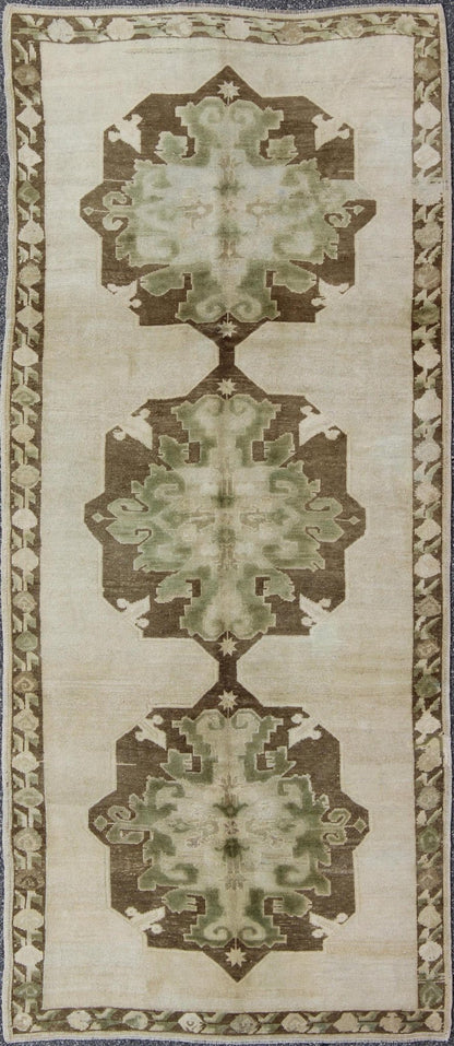 Green Turkish Oushak Runner This lovely Oushak runner displays three elegant medallions of multi - green colors on a solid cream field. The variety of green colors includes olive green, crocodile green and seaweed green. The minimal border coordin... - Keivan Woven ArtsTU - ISA - 3362 - 5740Rug