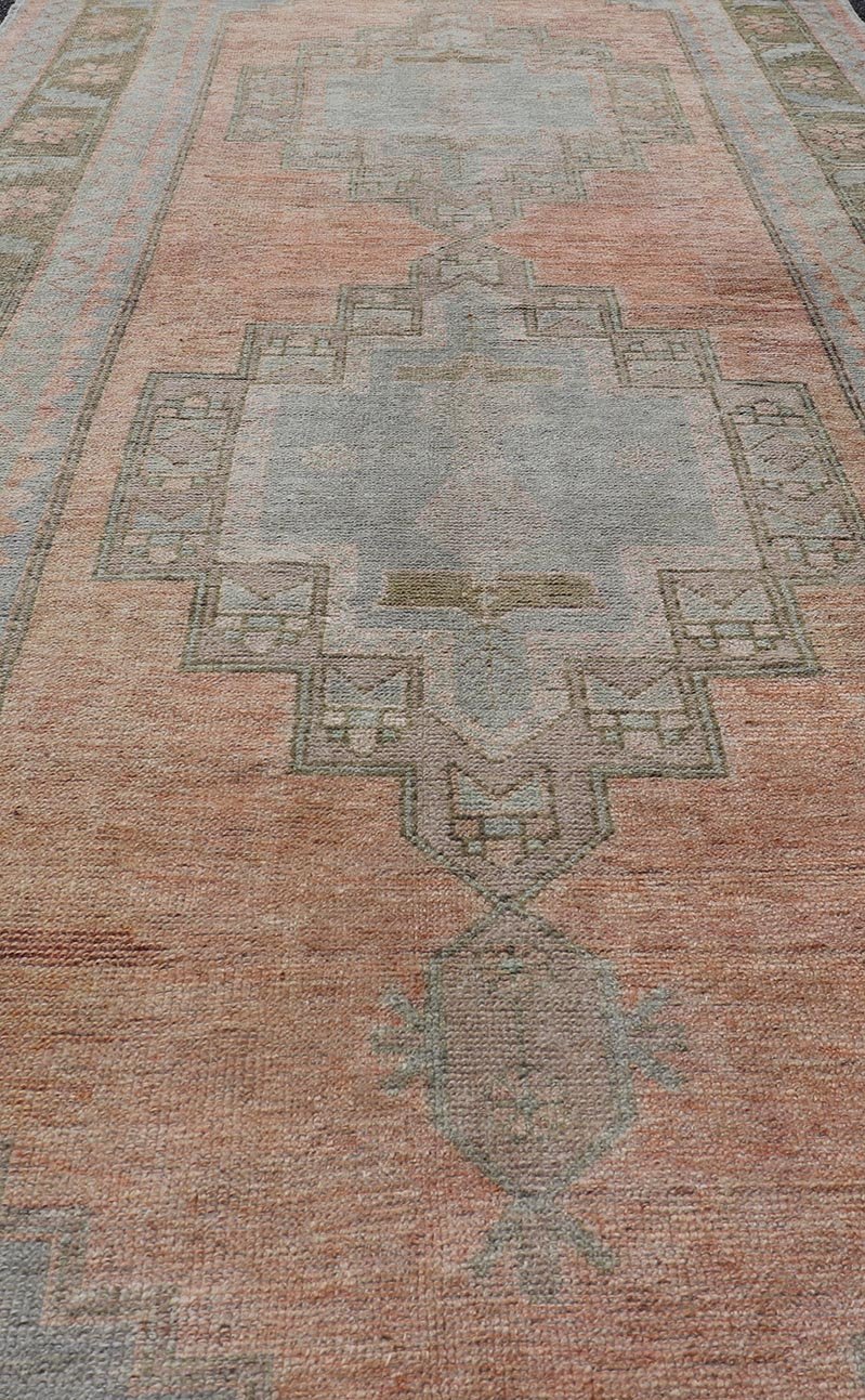 Vintage Turkish Oushak Gallery with Tribal Medallions in Soft Peach and Green Measures: 4'7 x 11'2 This vintage Turkish Oushak features large tribal medallions in light blue and tan. The medallions are decorated in tribal motifs and a p... - Keivan Woven ArtsTU - MTU - 117 - 18740Rug