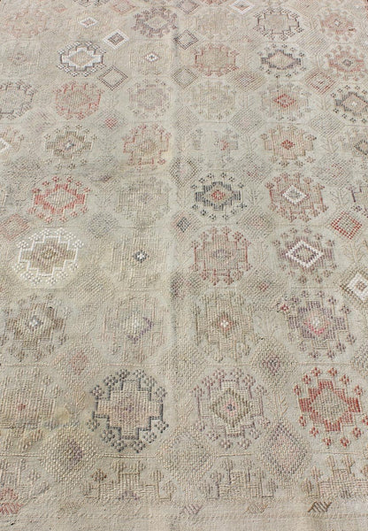 Vintage Turkish Kilim Featuring Muted Colors and All - Over Tribal Motif Design Measures 4'7 x 8'0 This rug features an asymmetrical design of tribal crests decorating the light blue - grey field. The crests are rendered in varying muted shades ... - Keivan Woven ArtsTU - NED - 136032 - 4618Rug