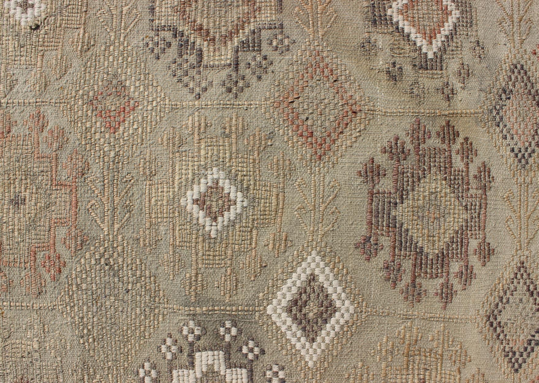 Vintage Turkish Kilim Featuring Muted Colors and All - Over Tribal Motif Design Measures 4'7 x 8'0 This rug features an asymmetrical design of tribal crests decorating the light blue - grey field. The crests are rendered in varying muted shades ... - Keivan Woven ArtsTU - NED - 136032 - 4618Rug