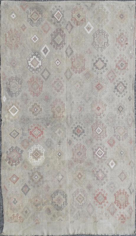 Vintage Turkish Kilim Featuring Muted Colors and All - Over Tribal Motif Design Measures 4'7 x 8'0 This rug features an asymmetrical design of tribal crests decorating the light blue - grey field. The crests are rendered in varying muted shades ... - Keivan Woven ArtsTU - NED - 136032 - 4618