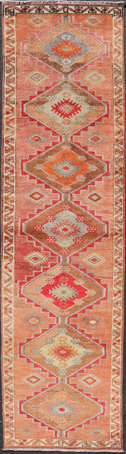 Measures: 2'10 x 11'10 Vintage Turkish Oushak Runner with Tribal Medallions in Redish Tones. Keivan Woven Arts / rug TU - NED - 4688, country of origin / type: Turkey / Oushak, circa 1950. This vintage Oushak runner features a unique blend of cheerfu... - Keivan Woven ArtsTU - NED - 4688 - 22111Rug