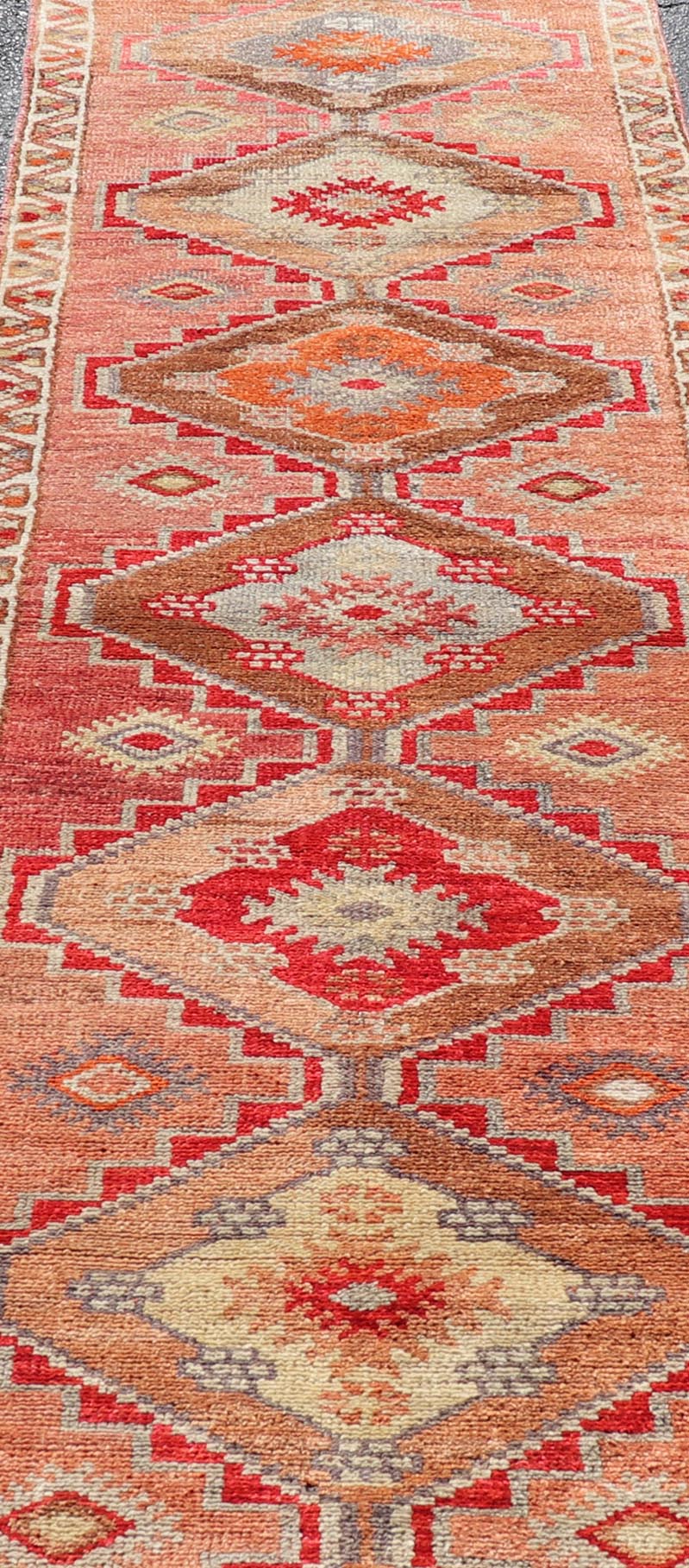 Measures: 2'10 x 11'10 Vintage Turkish Oushak Runner with Tribal Medallions in Redish Tones. Keivan Woven Arts / rug TU - NED - 4688, country of origin / type: Turkey / Oushak, circa 1950. This vintage Oushak runner features a unique blend of cheerfu... - Keivan Woven ArtsTU - NED - 4688 - 22111Rug