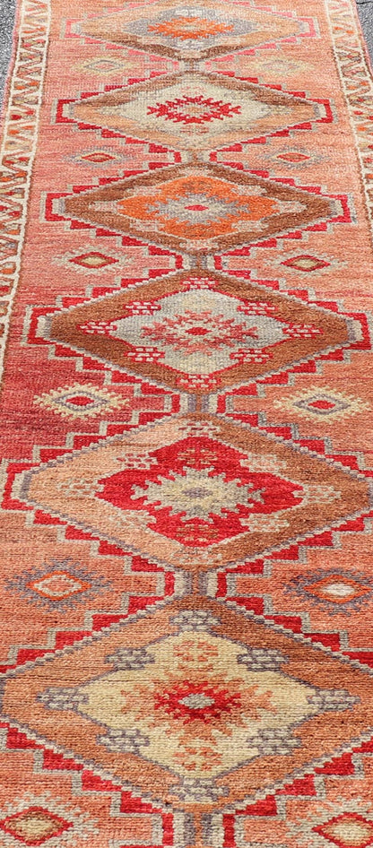 Measures: 2'10 x 11'10 Vintage Turkish Oushak Runner with Tribal Medallions in Redish Tones. Keivan Woven Arts / rug TU - NED - 4688, country of origin / type: Turkey / Oushak, circa 1950. This vintage Oushak runner features a unique blend of cheerfu... - Keivan Woven ArtsTU - NED - 4688 - 22111Rug