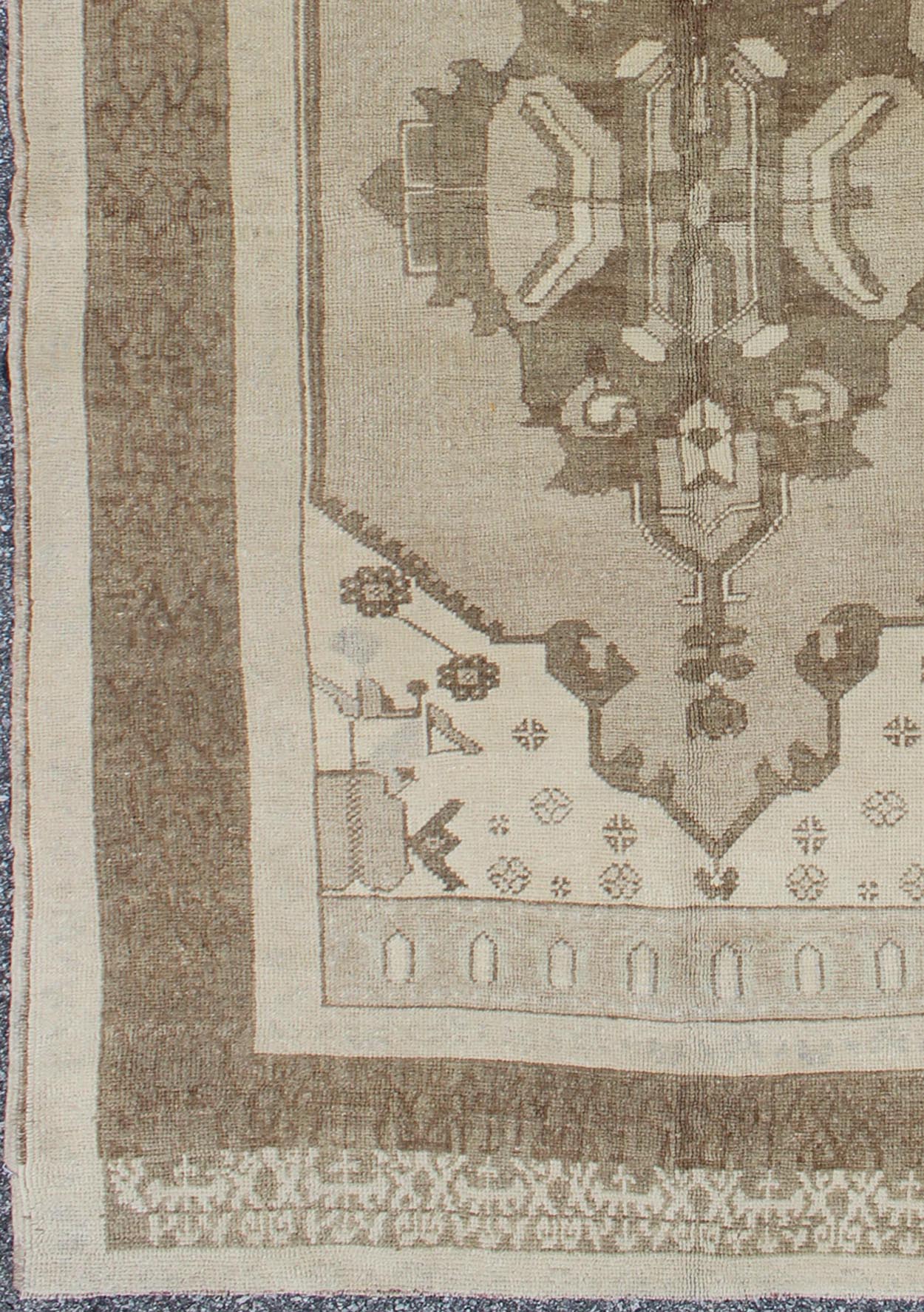 This Vintage Turkish Oushak is set on a taupe background. The geometric medallion features light green and brown with accents of darker brown. The border is very modern with unique motifs, while the overall feel of the piece is muted and contemporary. ... - Keivan Woven ArtsTU - TRS - 112964 - 3594Rug