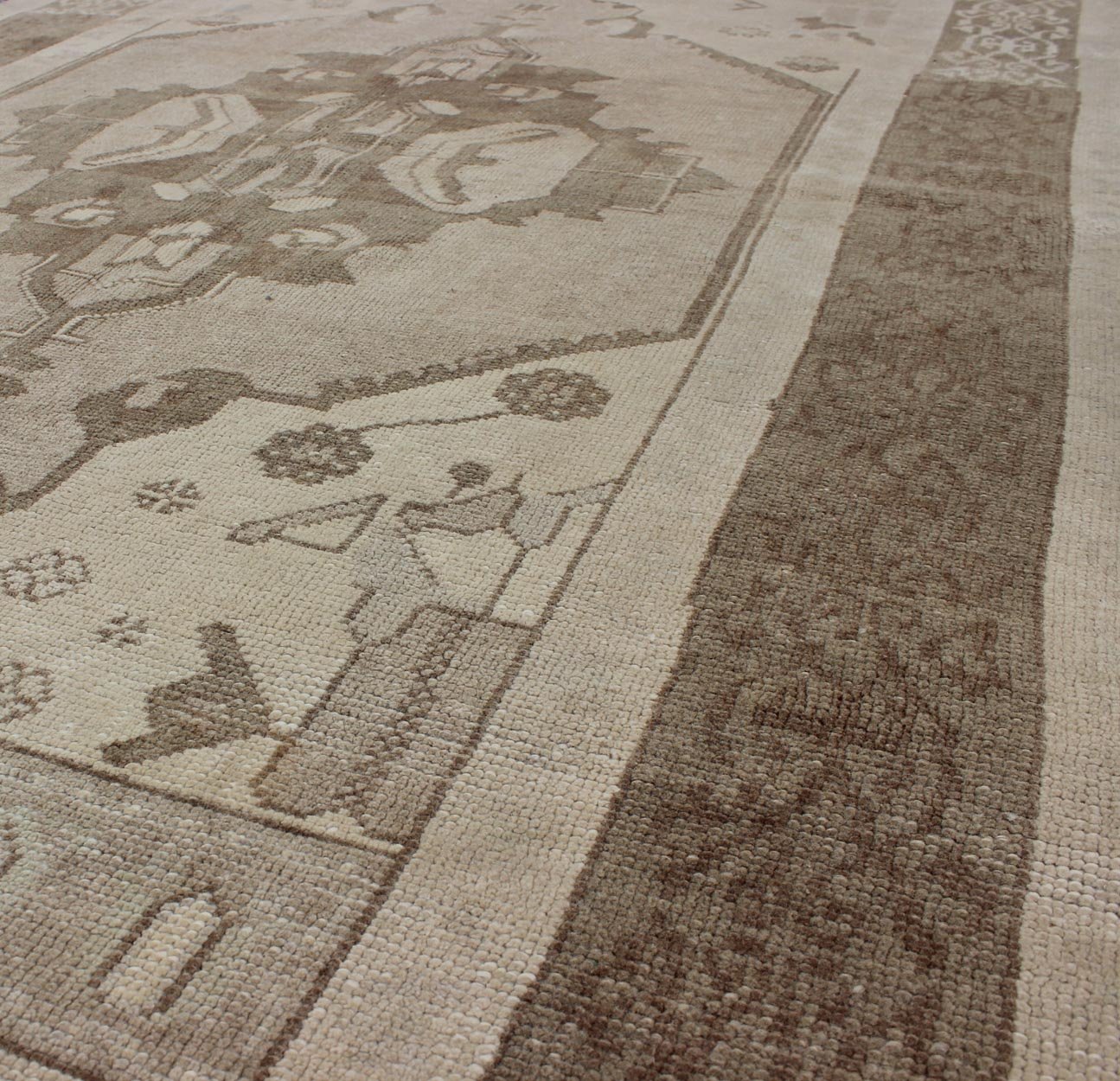 This Vintage Turkish Oushak is set on a taupe background. The geometric medallion features light green and brown with accents of darker brown. The border is very modern with unique motifs, while the overall feel of the piece is muted and contemporary. ... - Keivan Woven ArtsTU - TRS - 112964 - 3594