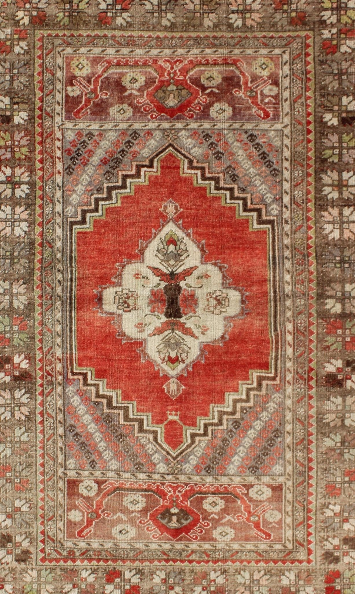 This antique Oushak bears a stylized medallion that commands the center field. A broad border of repeating motifs and floral patterns enclose the entire rug. Coral and light green colors complement the light brown, sub - geometric border. Turkish... - Keivan Woven ArtsTU - TRS - 136037 - 5048Rug