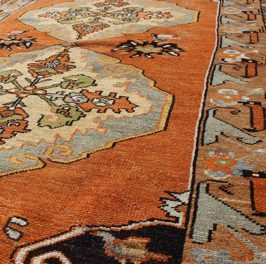 Vintage Turkish Tribal Medallion Area Rug in Orange, Green, Brown, and Blue Measures: 3'9 x 6'5 This vibrantly colored Turkish Oushak features two medallions and a highly detailed design set on an orange background with dark brown and lig... - Keivan Woven ArtsTU - TRS - 3259 - 5848Rug