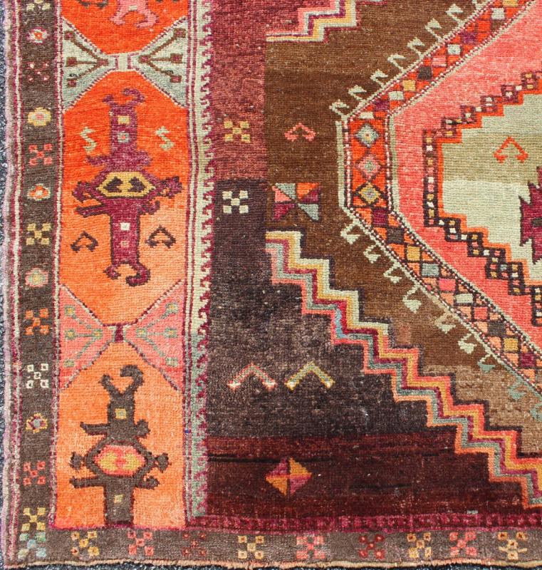 Large Gallery Rug with Geometric Medallions in Dark Brown, Orange & Multi Colors. Vintage wide and long gallery runner from Turkey with geometric layered Medallion design in Brown background and various tones of orange, coral, salmon, pink, ligh... - Keivan Woven ArtsTU - TRS - 3260 - 6418Rug