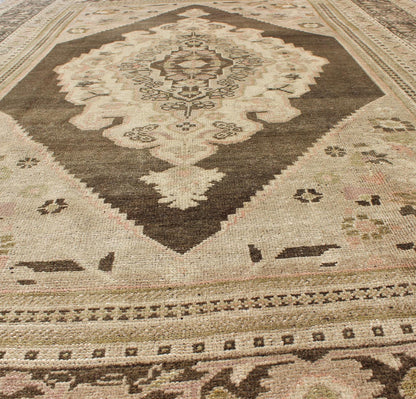 Measures: 6.1 x 9.8 Set on a muddy green background, this vintage Turkish Oushak displays a rustic diamond medallion decorated with vines and flora. The darker border homes similar stylizations of floral motifs commonly seen with Oushaks from th... - Keivan Woven ArtsTU - TRS - 95003 - 3880Rug