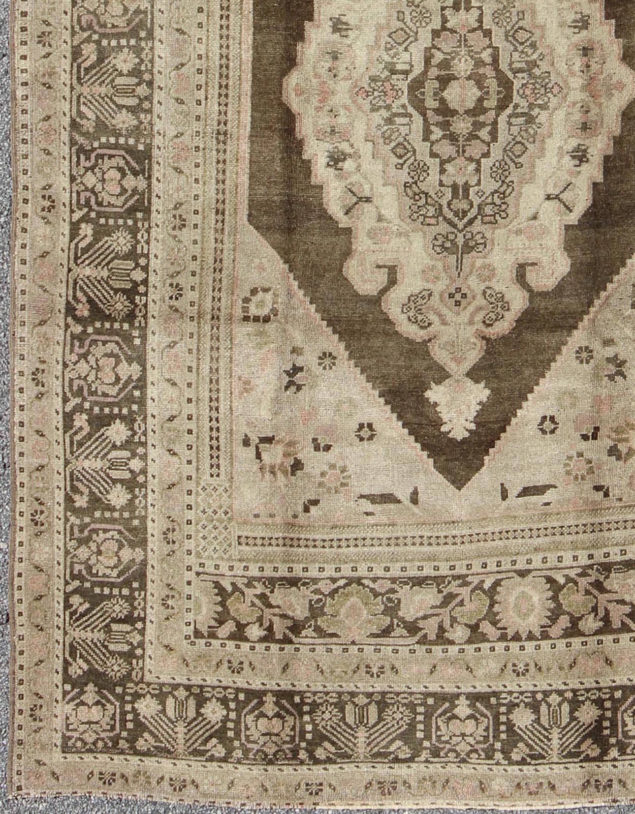 Measures: 6.1 x 9.8 Set on a muddy green background, this vintage Turkish Oushak displays a rustic diamond medallion decorated with vines and flora. The darker border homes similar stylizations of floral motifs commonly seen with Oushaks from th... - Keivan Woven ArtsTU - TRS - 95003 - 3880Rug