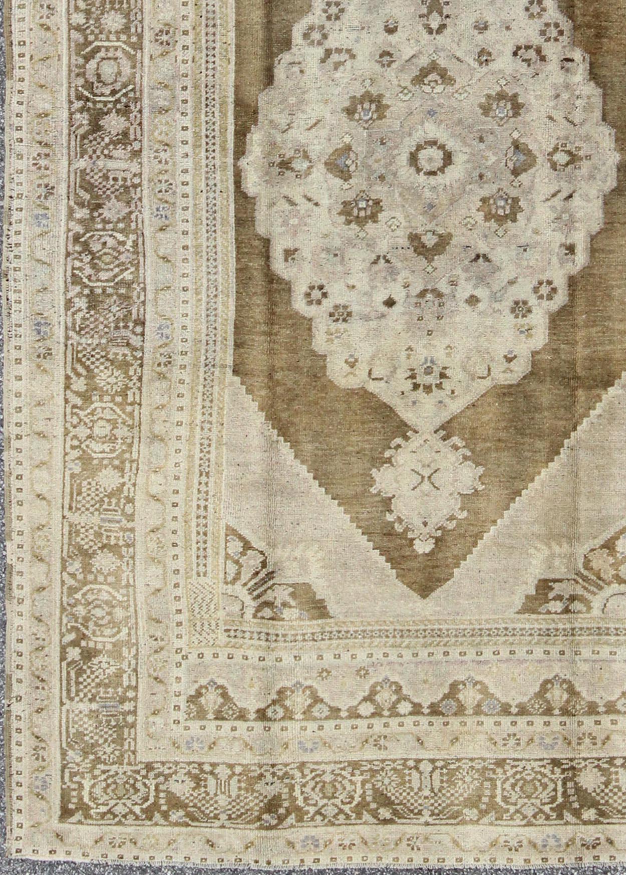 Vintage Turkish Floral Medallion Oushak Rug in Khaki and Brown Tones Measures: 5'11 x 9'6 Set on a khaki background and brown border, this vintage Turkish Oushak displays an unique earth tone color combination with various shades of taupe... - Keivan Woven ArtsTU - UGU - 11 - 3126Rug