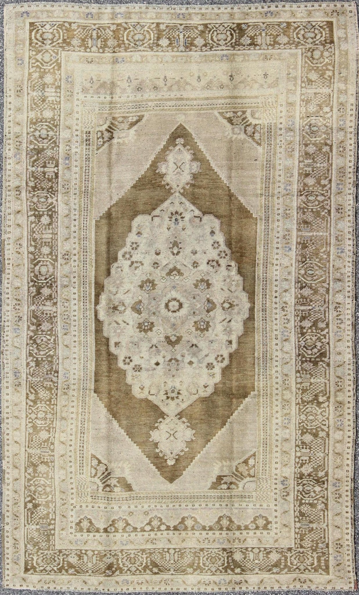 Vintage Turkish Floral Medallion Oushak Rug in Khaki and Brown Tones Measures: 5'11 x 9'6 Set on a khaki background and brown border, this vintage Turkish Oushak displays an unique earth tone color combination with various shades of taupe... - Keivan Woven ArtsTU - UGU - 11 - 3126Rug