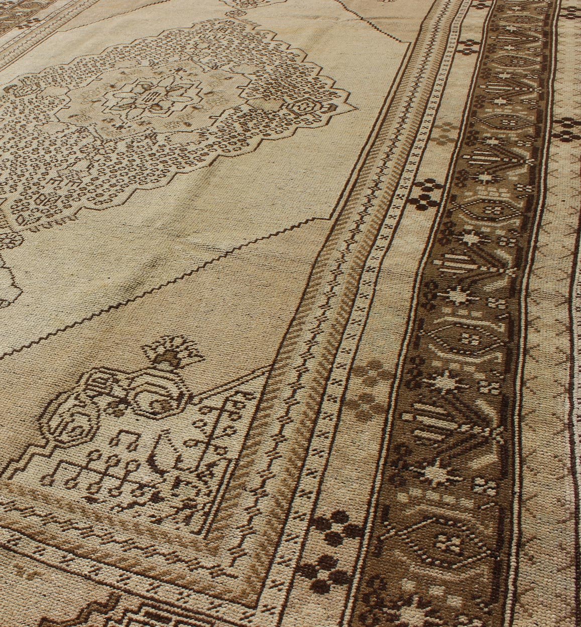 Vintage Turkish Stylized Medallion Oushak Rug in Sandy Neutrals and Earth Tones Measures: 5'7 x 10'2 This vintage Turkish Oushak sets on a neutral sandy ground with a central medallion stylized with small details. The background is ... - Keivan Woven ArtsTU - UGU - 56 - 2854Rug