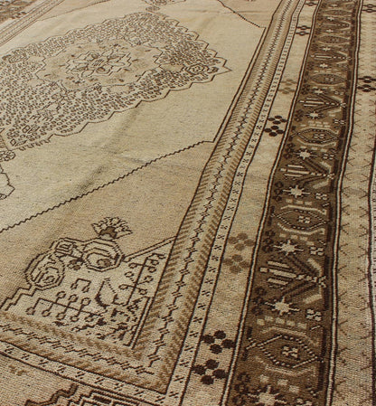 Vintage Turkish Stylized Medallion Oushak Rug in Sandy Neutrals and Earth Tones Measures: 5'7 x 10'2 This vintage Turkish Oushak sets on a neutral sandy ground with a central medallion stylized with small details. The background is ... - Keivan Woven ArtsTU - UGU - 56 - 2854Rug