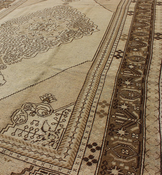Vintage Turkish Stylized Medallion Oushak Rug in Sandy Neutrals and Earth Tones Measures: 5'7 x 10'2 This vintage Turkish Oushak sets on a neutral sandy ground with a central medallion stylized with small details. The background is ... - Keivan Woven ArtsTU - UGU - 56 - 2854Rug