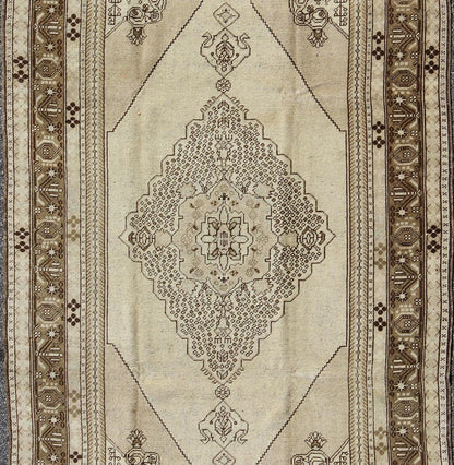 Vintage Turkish Stylized Medallion Oushak Rug in Sandy Neutrals and Earth Tones Measures: 5'7 x 10'2 This vintage Turkish Oushak sets on a neutral sandy ground with a central medallion stylized with small details. The background is ... - Keivan Woven ArtsTU - UGU - 56 - 2854Rug