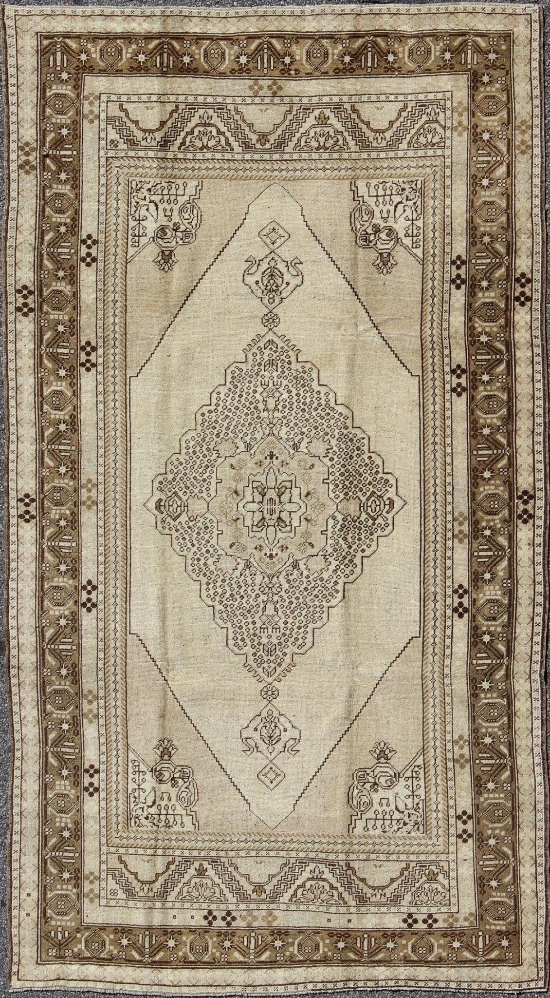 Vintage Turkish Stylized Medallion Oushak Rug in Sandy Neutrals and Earth Tones Measures: 5'7 x 10'2 This vintage Turkish Oushak sets on a neutral sandy ground with a central medallion stylized with small details. The background is ... - Keivan Woven ArtsTU - UGU - 56 - 2854Rug