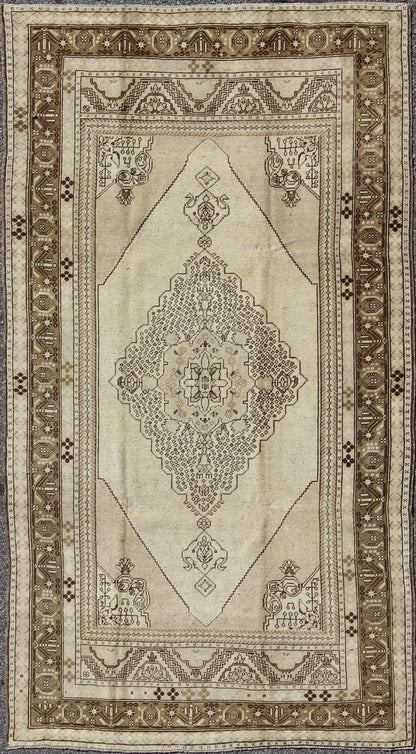 Vintage Turkish Stylized Medallion Oushak Rug in Sandy Neutrals and Earth Tones Measures: 5'7 x 10'2 This vintage Turkish Oushak sets on a neutral sandy ground with a central medallion stylized with small details. The background is ... - Keivan Woven ArtsTU - UGU - 56 - 2854Rug