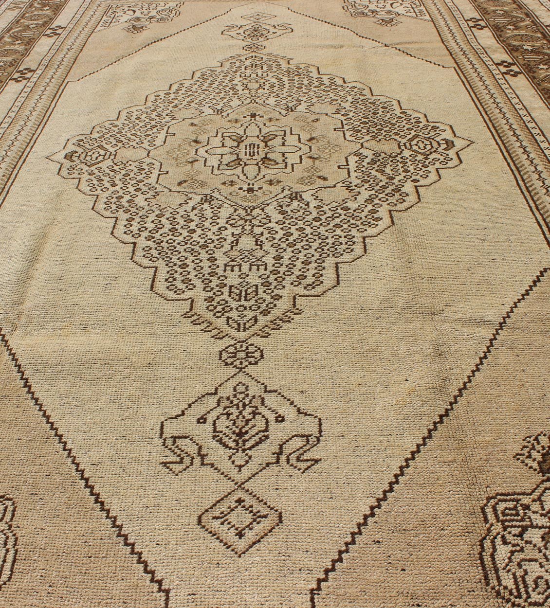 Vintage Turkish Stylized Medallion Oushak Rug in Sandy Neutrals and Earth Tones Measures: 5'7 x 10'2 This vintage Turkish Oushak sets on a neutral sandy ground with a central medallion stylized with small details. The background is ... - Keivan Woven ArtsTU - UGU - 56 - 2854Rug