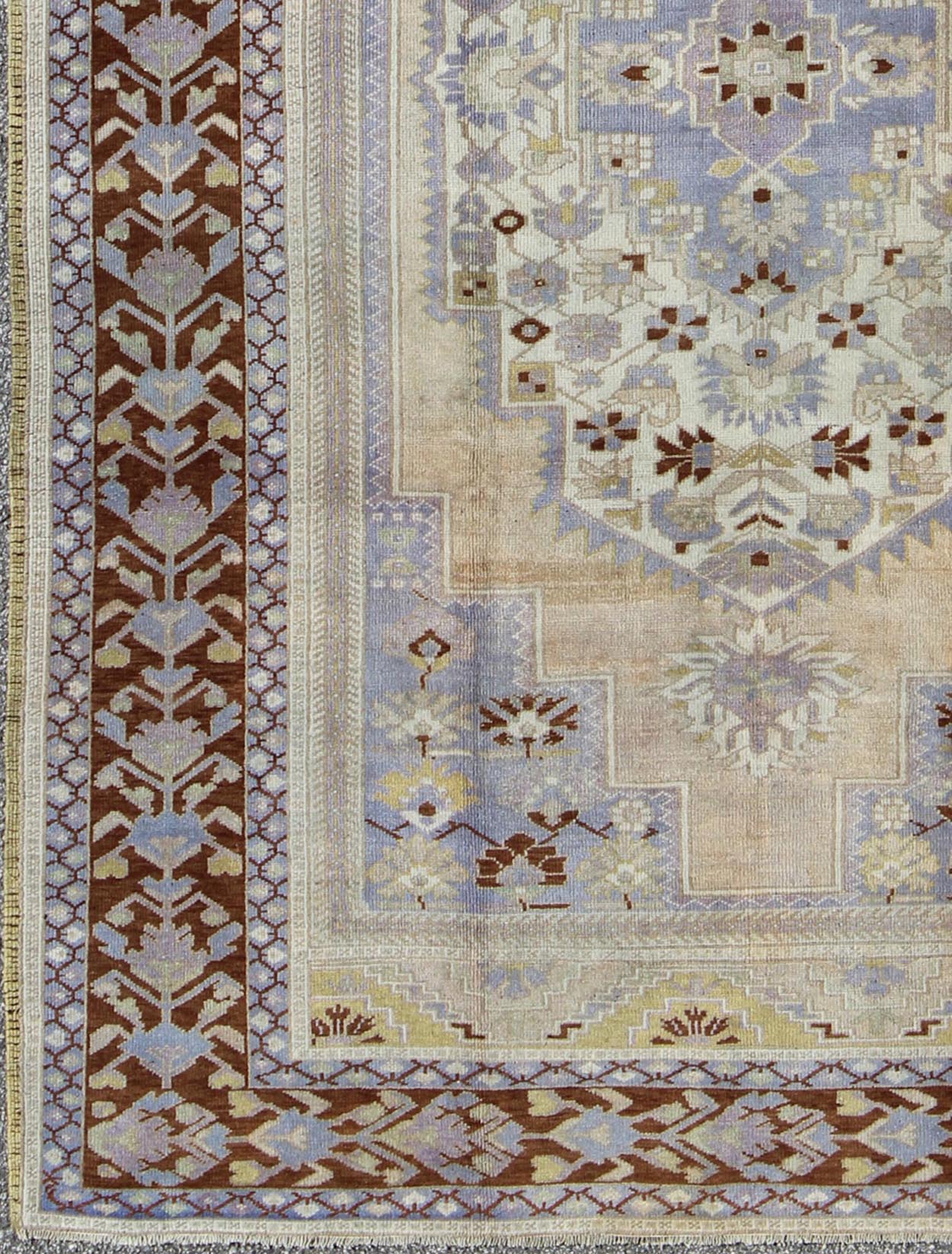 Vintage Turkish Oushak - This stunning vintage Turkish Oushak rug shows a charming combination of warm and cool colors. Set on a brown border with a pop of the same brown throughout, this unique Oushak displays light purple, cream, beige, soft yellow, gr... - Keivan Woven ArtsTU - YUN - 136075 - 4702Rug