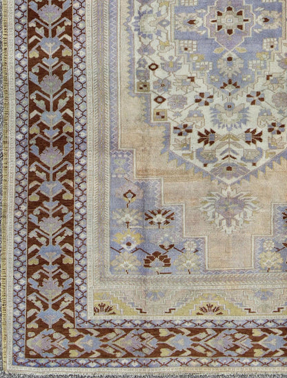 Vintage Turkish Oushak - This stunning vintage Turkish Oushak rug shows a charming combination of warm and cool colors. Set on a brown border with a pop of the same brown throughout, this unique Oushak displays light purple, cream, beige, soft yellow, gr... - Keivan Woven ArtsTU - YUN - 136075 - 4702Rug