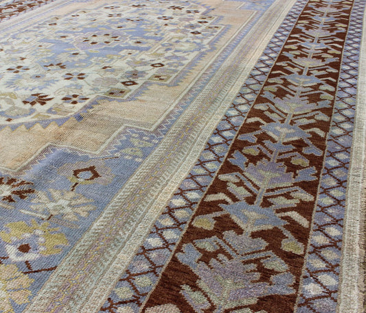 Vintage Turkish Oushak - This stunning vintage Turkish Oushak rug shows a charming combination of warm and cool colors. Set on a brown border with a pop of the same brown throughout, this unique Oushak displays light purple, cream, beige, soft yellow, gr... - Keivan Woven ArtsTU - YUN - 136075 - 4702Rug