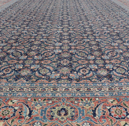 Antique Hand - Knotted Persian Tabriz with Sub - Geometric Floral Design in Wool This antique Persian Tabriz rug features an all - over, sub - geometric floral design rendered in green, coral, orange, ivory and blue shades, set upon a navy blue backgro... - Keivan Woven ArtsV21 - 1206 - 18431Rug