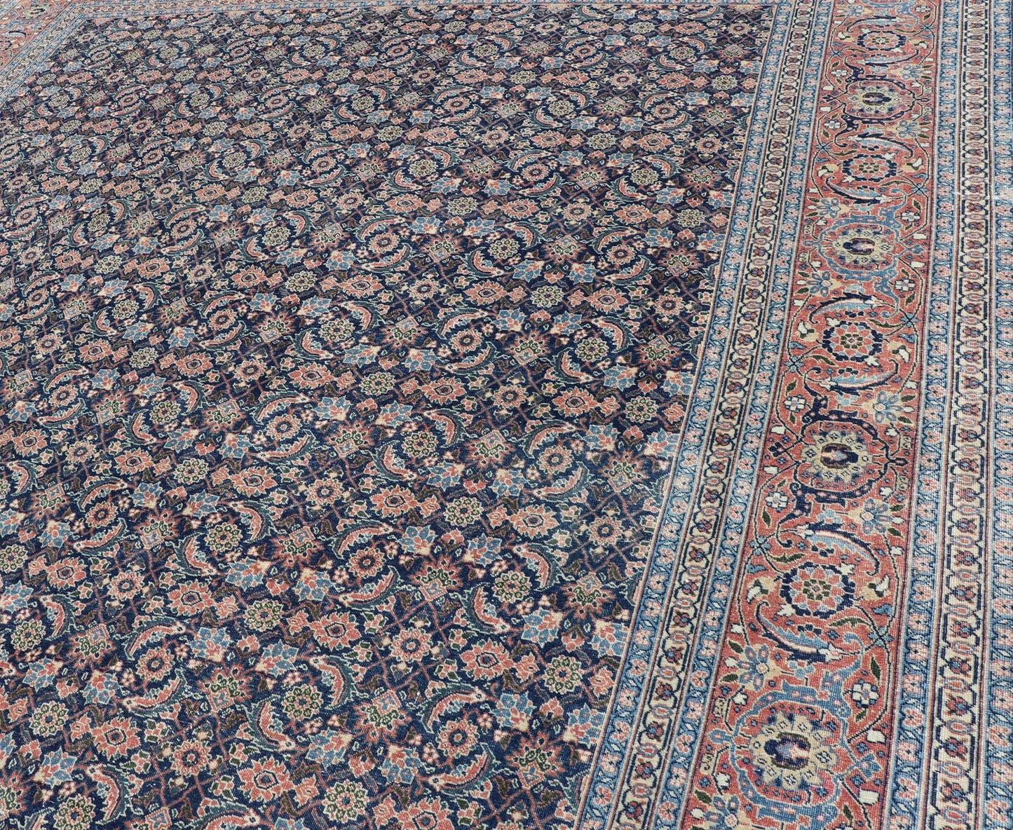 Antique Hand - Knotted Persian Tabriz with Sub - Geometric Floral Design in Wool This antique Persian Tabriz rug features an all - over, sub - geometric floral design rendered in green, coral, orange, ivory and blue shades, set upon a navy blue backgro... - Keivan Woven ArtsV21 - 1206 - 18431