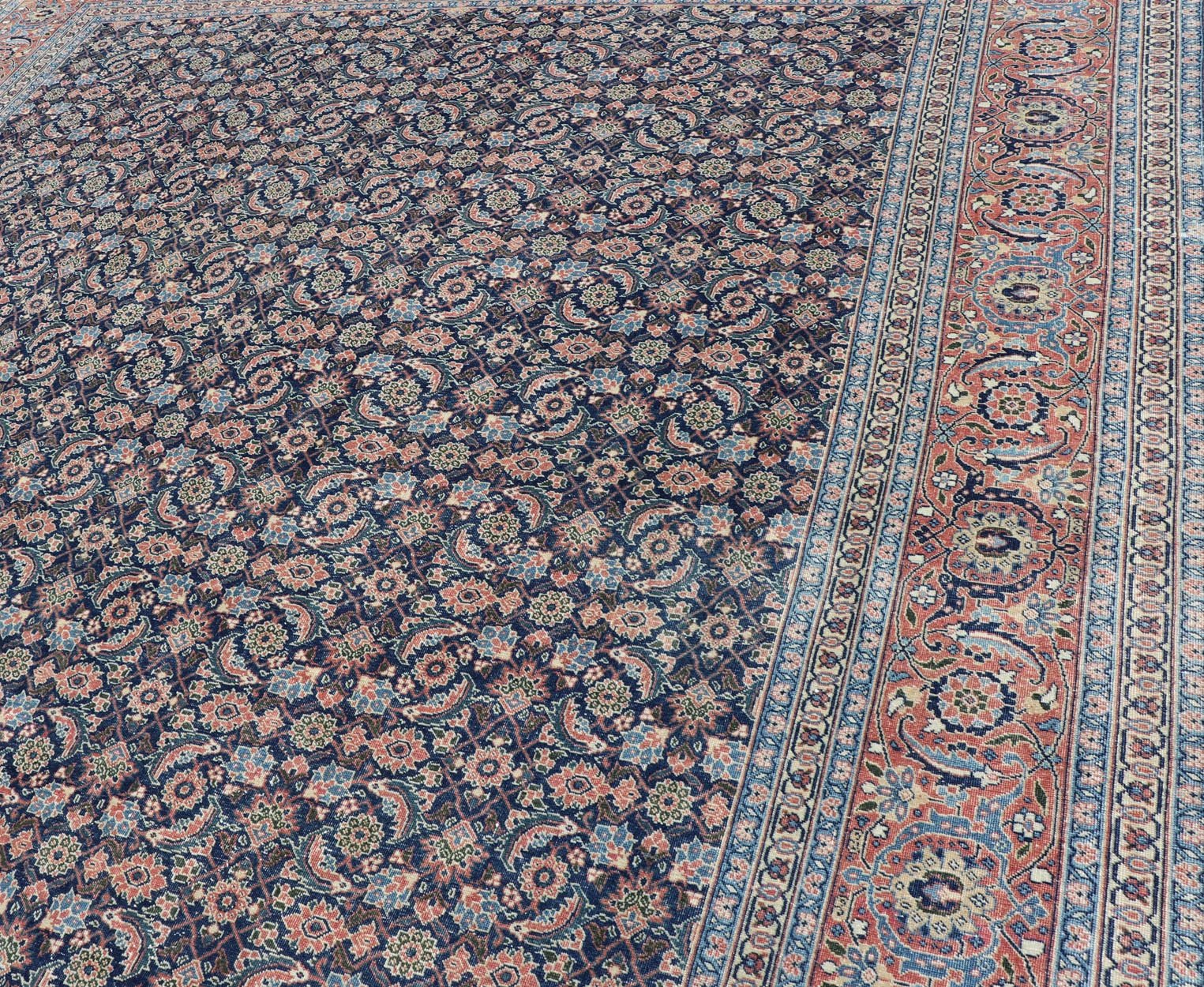 Antique Hand - Knotted Persian Tabriz with Sub - Geometric Floral Design in Wool This antique Persian Tabriz rug features an all - over, sub - geometric floral design rendered in green, coral, orange, ivory and blue shades, set upon a navy blue backgro... - Keivan Woven ArtsV21 - 1206 - 18431