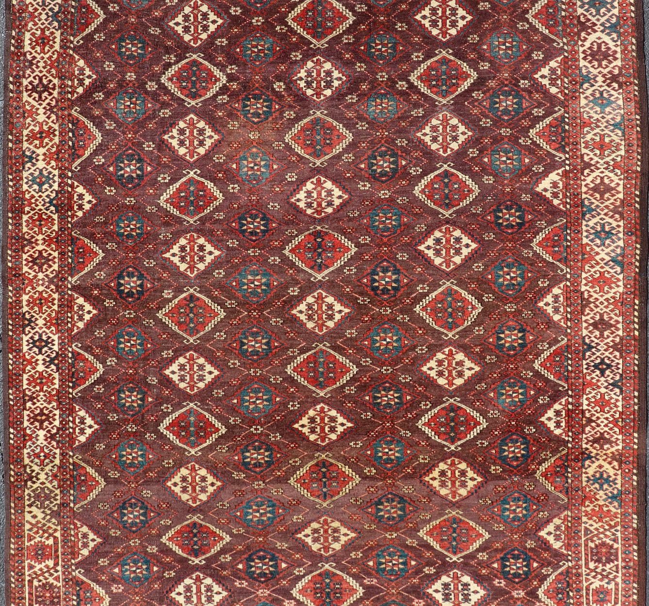 Early 19th century Chodor main carpet from Turkmenistan Antique Turkomen Rug in Wool with Repeating Gul Design in Brown, Blue, and Red. Keivan Woven Arts; rug X23 - 0306 - 201, country of origin / type: Turkestan / Turkomen circa 1820s. Measure... - Keivan Woven ArtsX23 - 0306 - 201 - 23547