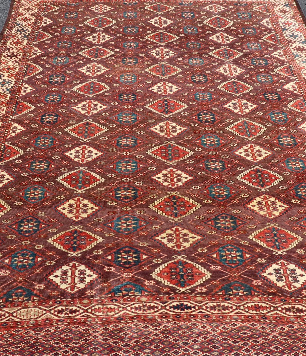 Early 19th century Chodor main carpet from Turkmenistan Antique Turkomen Rug in Wool with Repeating Gul Design in Brown, Blue, and Red. Keivan Woven Arts; rug X23 - 0306 - 201, country of origin / type: Turkestan / Turkomen circa 1820s. Measure... - Keivan Woven ArtsX23 - 0306 - 201 - 23547
